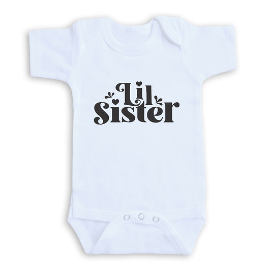 A white baby onesie with the text "Lil Sister" printed on it.