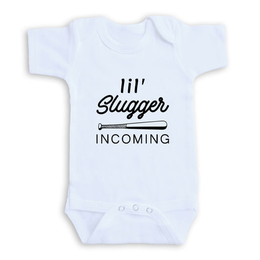 A white baby onesie with the text "I'll Slugger Coming" printed on it.