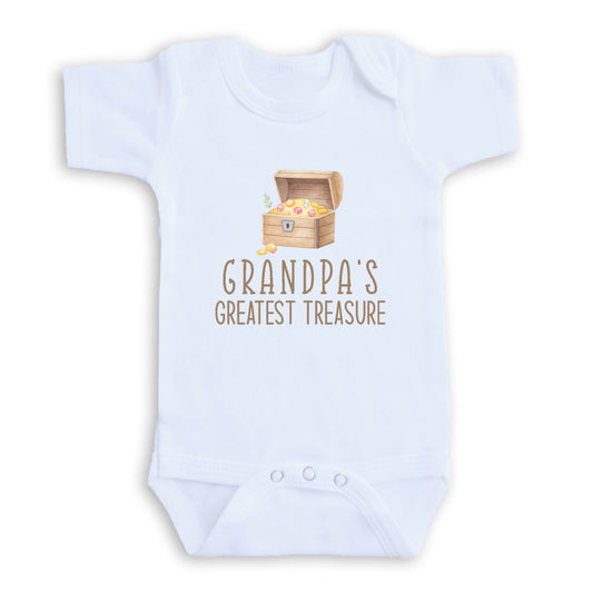 A white baby onesie with a graphic of a wooden chest containing gold coins and the text "GRANDPA'S GREATEST TREASURE" printed on it.