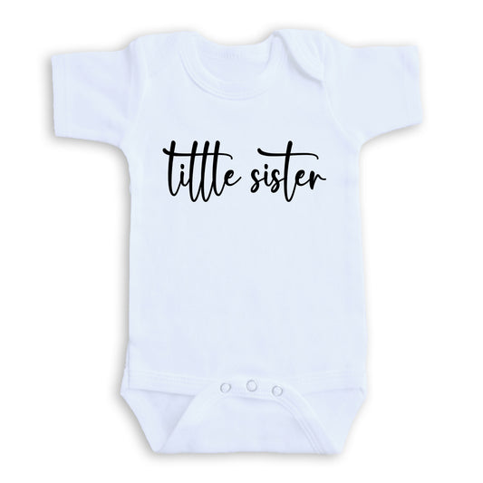 A white baby onesie with the text "title sister" printed on it.
