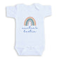 A white baby onesie with a rainbow graphic and the text "auntie's bestie" printed on it.