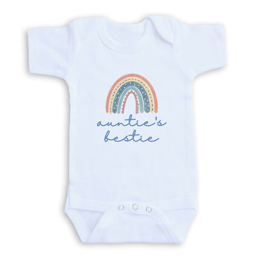 A white baby onesie with a rainbow graphic and the text "auntie's bestie" printed on it.
