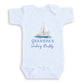 A white baby onesie with a sailboat graphic and the text "Grandpa's Sailing Buddy" printed on it.
