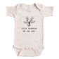 A baby onesie with a reindeer design and the text "Little reindeer on the way" printed on it.