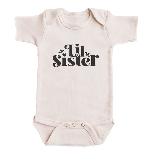 A baby onesie with the text "Lil Sister" printed on it.