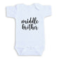 A white baby onesie with the text "middle brother" printed on it.