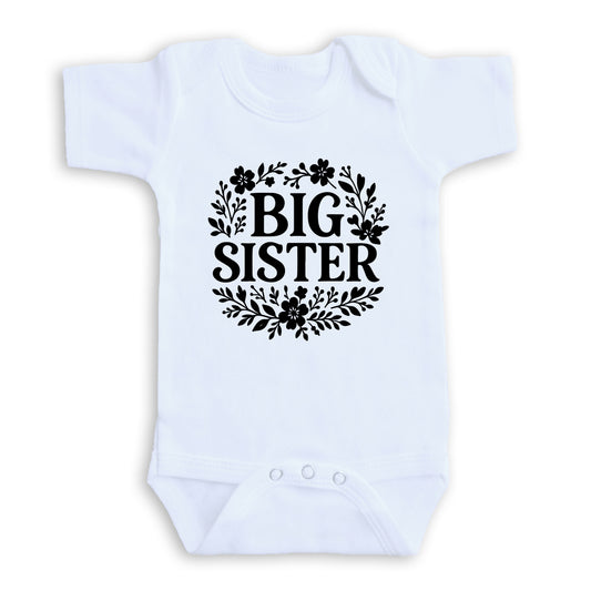 A white baby onesie with the text "BIG SISTER" printed on it.
