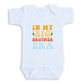 A white baby onesie with the text "IN MY BIG BROTHER ERA" printed on it.