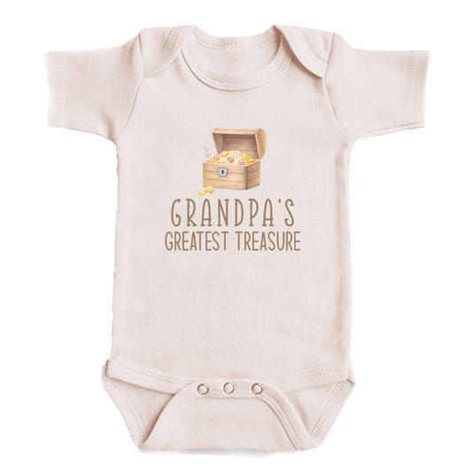 A baby onesie with a graphic of a chest containing gold coins and the text "GRANDPA'S GREATEST TREASURE" printed on it.