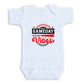 A white baby onesie with a graphic design on it.