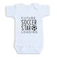 A white baby onesie with the text "FUTURE SOCCER STAR LOADING" printed on it.