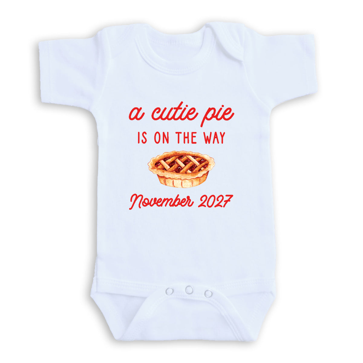 A white baby onesie with a red text and graphic design that reads "a cute pie is on the way November 2027".