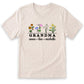 A light-colored t-shirt with a graphic design featuring a row of colorful flowers and the text "GRANDMA" below them.