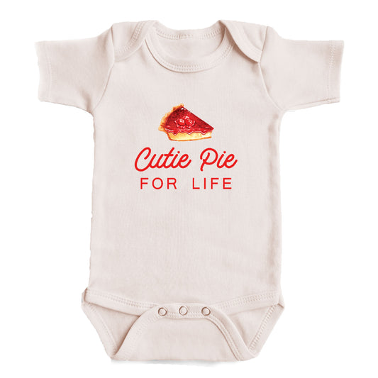 A baby onesie with a printed design of a slice of pie and the text "Cutie Pie for Life" printed on it.