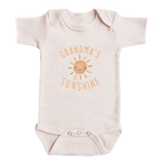 A baby onesie with the text "GRANDMA'S SUNSHINE" printed on it.