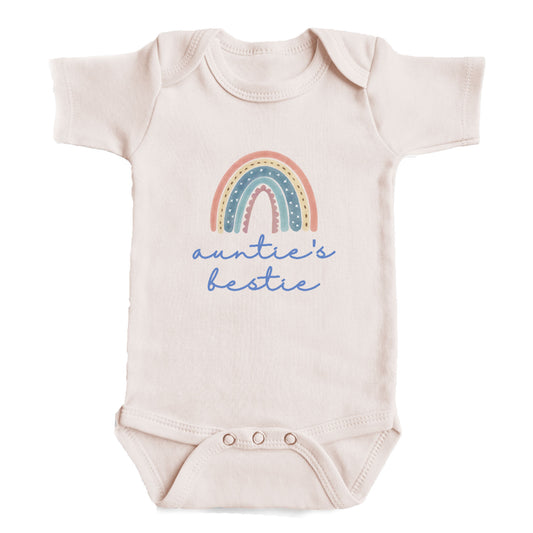 A baby onesie with a rainbow graphic and the text "auntie's bestie" printed on it.