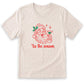 A white t-shirt with a graphic design depicting a smiling Santa Claus holding a martini glass, accompanied by the text "Tis the season" in red.