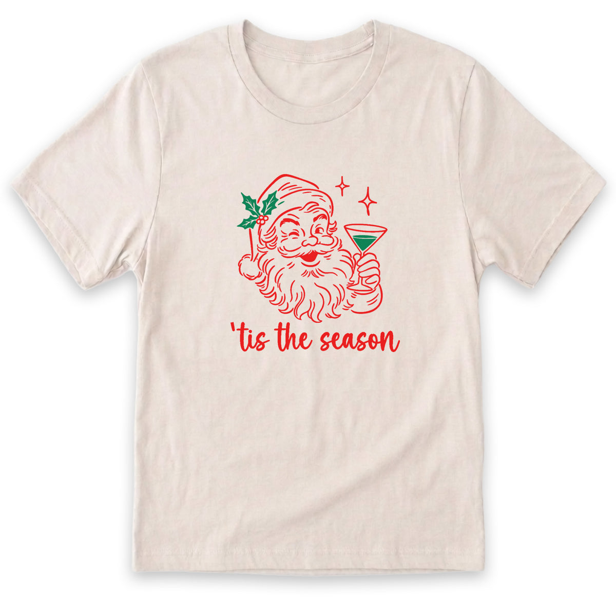 A white t-shirt with a graphic design depicting a smiling Santa Claus holding a martini glass, accompanied by the text "Tis the season" in red.