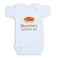 A white baby onesie with a printed design of a pie and the text "Grandma's SWEETIE PIE" printed on it.