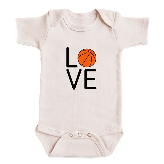 A white baby onesie with the word "LOVE" printed on it, featuring an orange basketball graphic.