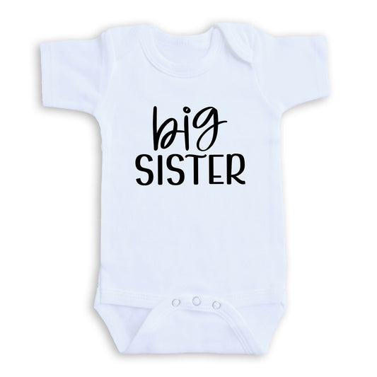 A white baby onesie with the text "big sister" printed on it.