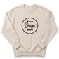 A beige sweater with a circular design featuring the text "Your Design Here" in black.