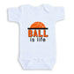 A white baby onesie with the text "BALL is life" printed on it.