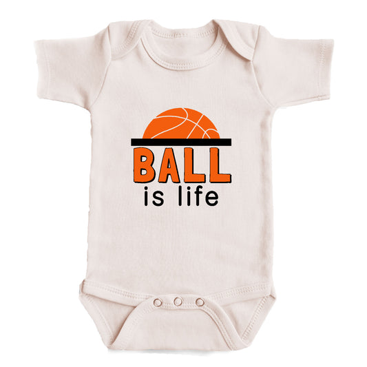 A white baby onesie with the text "BALL is life" printed on it.