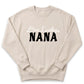 A beige sweatshirt with the text "One Lucky NANA" printed on it in black letters.