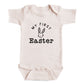 A baby onesie with the text "My first Easter" printed on it.