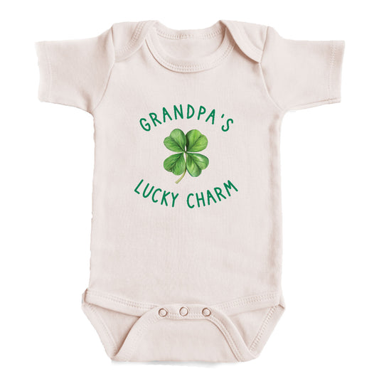 A baby onesie with the text "GRANDPA'S LUCKY CHARM" printed on it, along with a cloverleaf graphic.