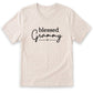 A beige t-shirt with the text "blessed Grammy" printed on it in a casual, handwritten style.