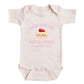 A baby onesie with a pink design and text on it.