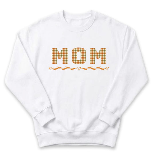A white sweatshirt with the word "MOM" printed on it in a checkered pattern.