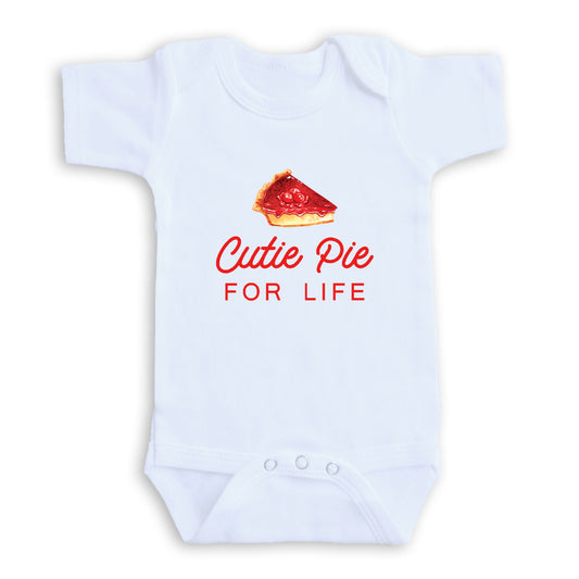 A white baby onesie with a red pie graphic and the text "Cutie Pie FOR LIFE" printed on it.
