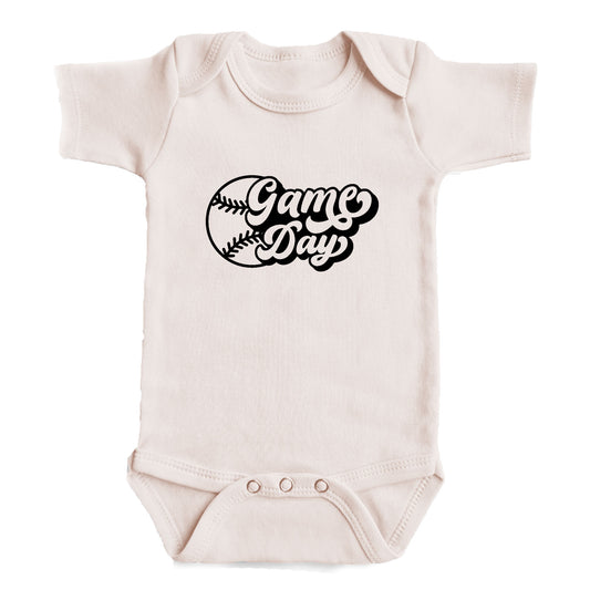 A baby onesie with the text "Game Day" printed on it.