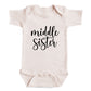 A baby onesie with the text "middle sister" printed on it.