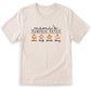 A beige t-shirt with a graphic design featuring three pumpkins and the text "mini's PUMPKIN PATCH alicia bally charl dany".
