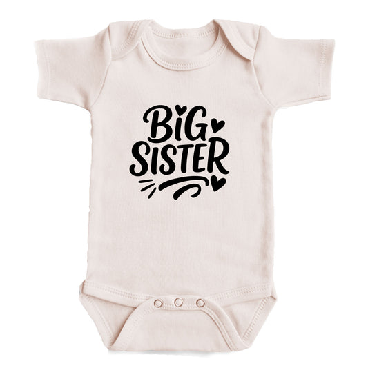 A baby onesie with the text "BIG SISTER" printed on it.