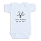 A white baby onesie with a black reindeer graphic and the text "LITTLE REINDeer ON THE WAY" printed on it.