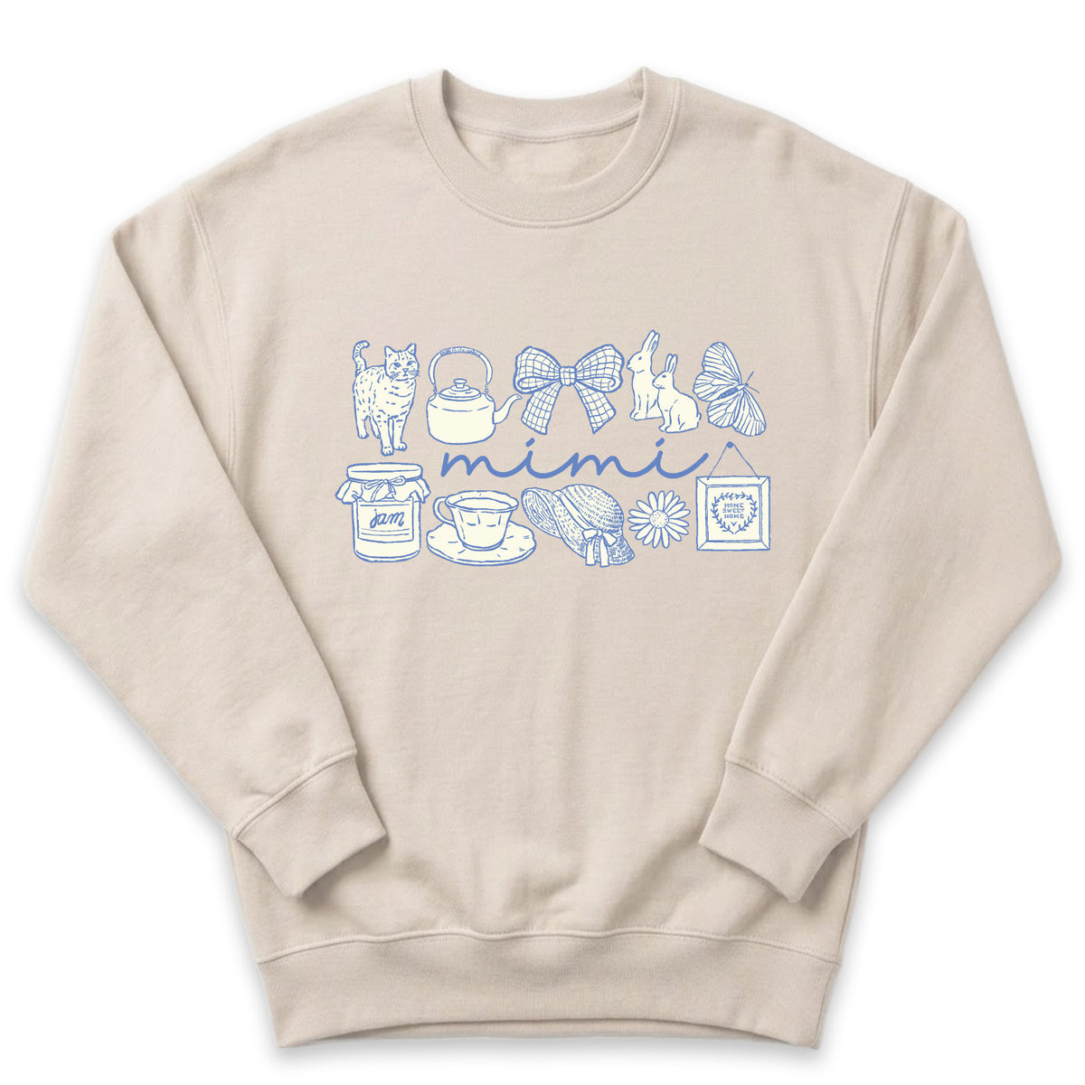 A beige sweatshirt with a graphic design featuring various objects such as a teapot, cat, butterfly, and other decorative elements arranged in a row.