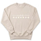 A beige sweatshirt with the text "in my gigi era" printed on it, along with a row of white flowers.