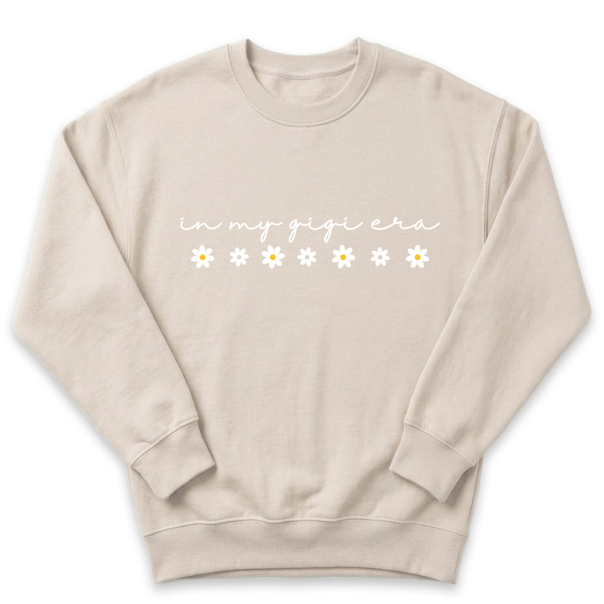 A beige sweatshirt with the text "in my gigi era" printed on it, along with a row of white flowers.