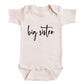 A baby onesie with the text "big sister" printed on it.