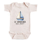 A baby onesie with a sailboat printed on it, and the text "LIL' ADVENTURER est. 2027" printed below the sailboat.