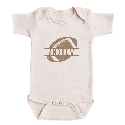 A baby onesie with a football graphic and the name "ANDREW" printed on it.