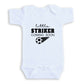 A white baby onesie with the text "little STRIKER COMING SOON" printed on it.