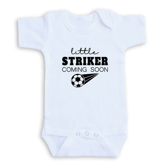 A white baby onesie with the text "little STRIKER COMING SOON" printed on it.