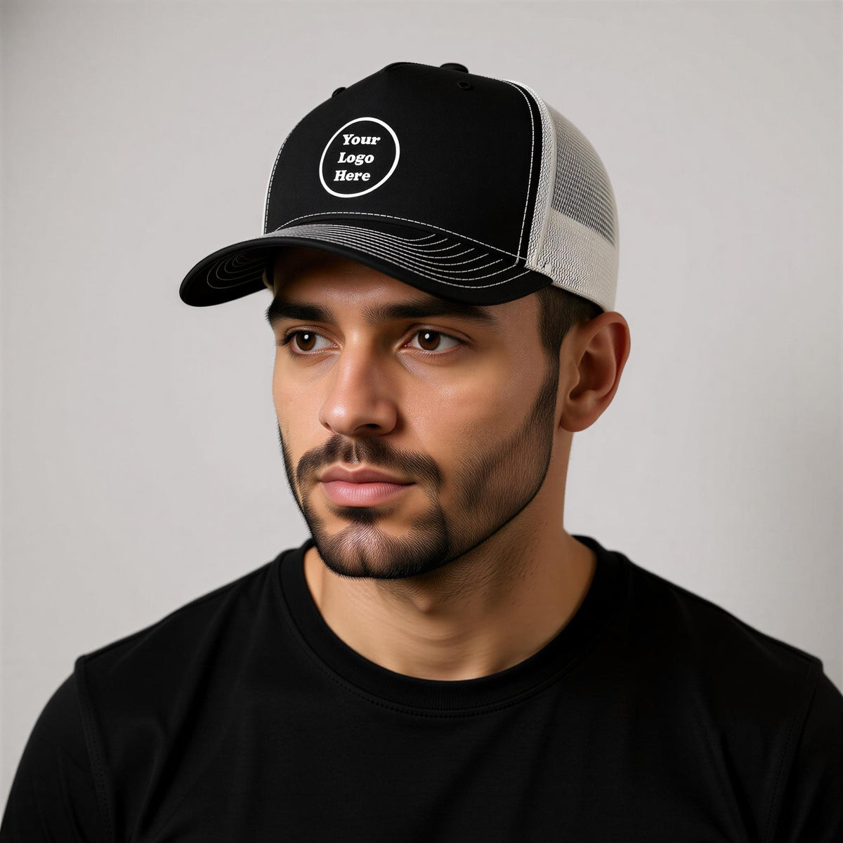 A man wearing a black baseball cap with a white logo on it.