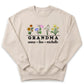 A beige sweatshirt with a graphic design featuring colorful flowers and the text "GRANDMA anna lisa michelle".